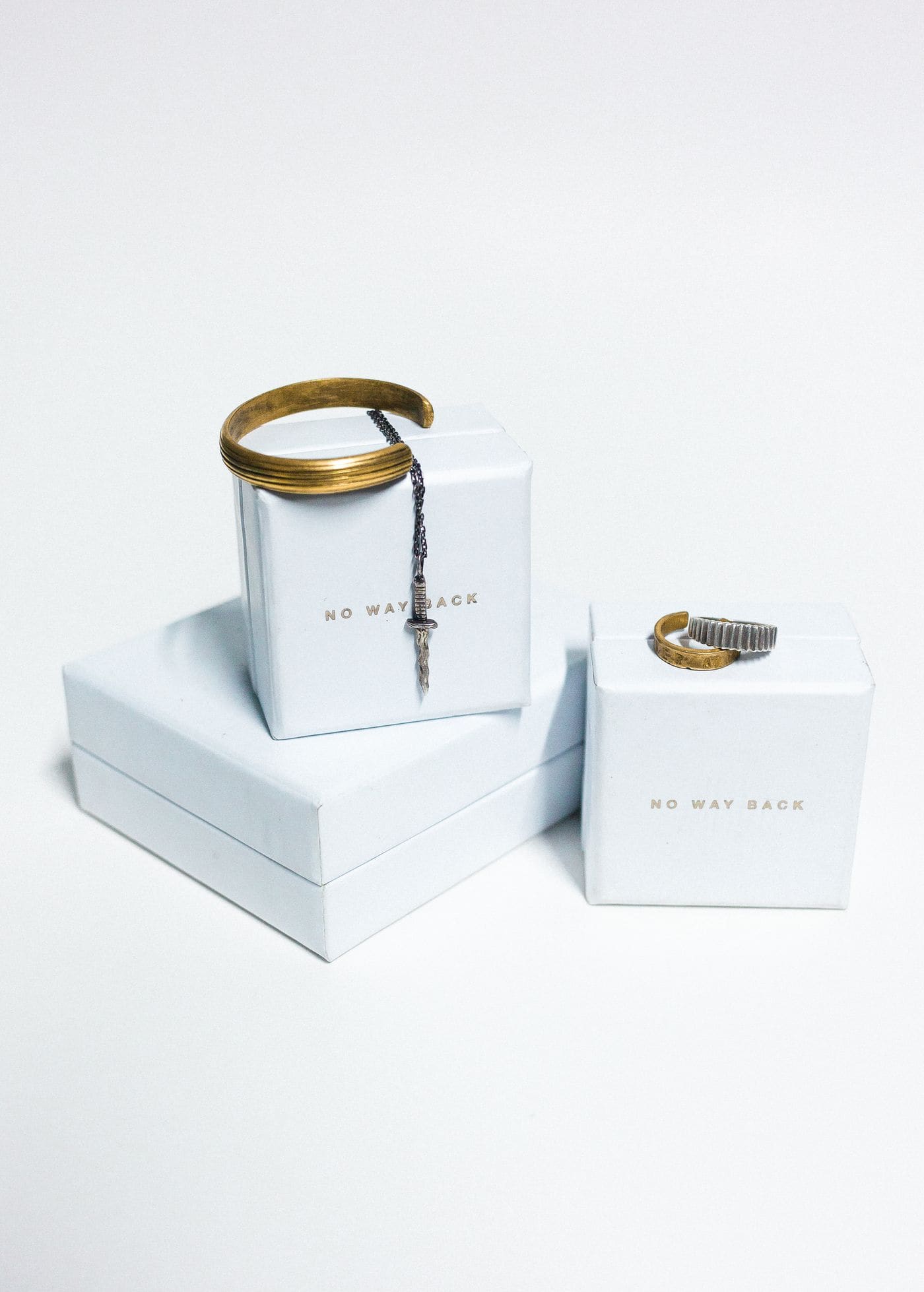 A gold ring resting on a white jewellery gift box